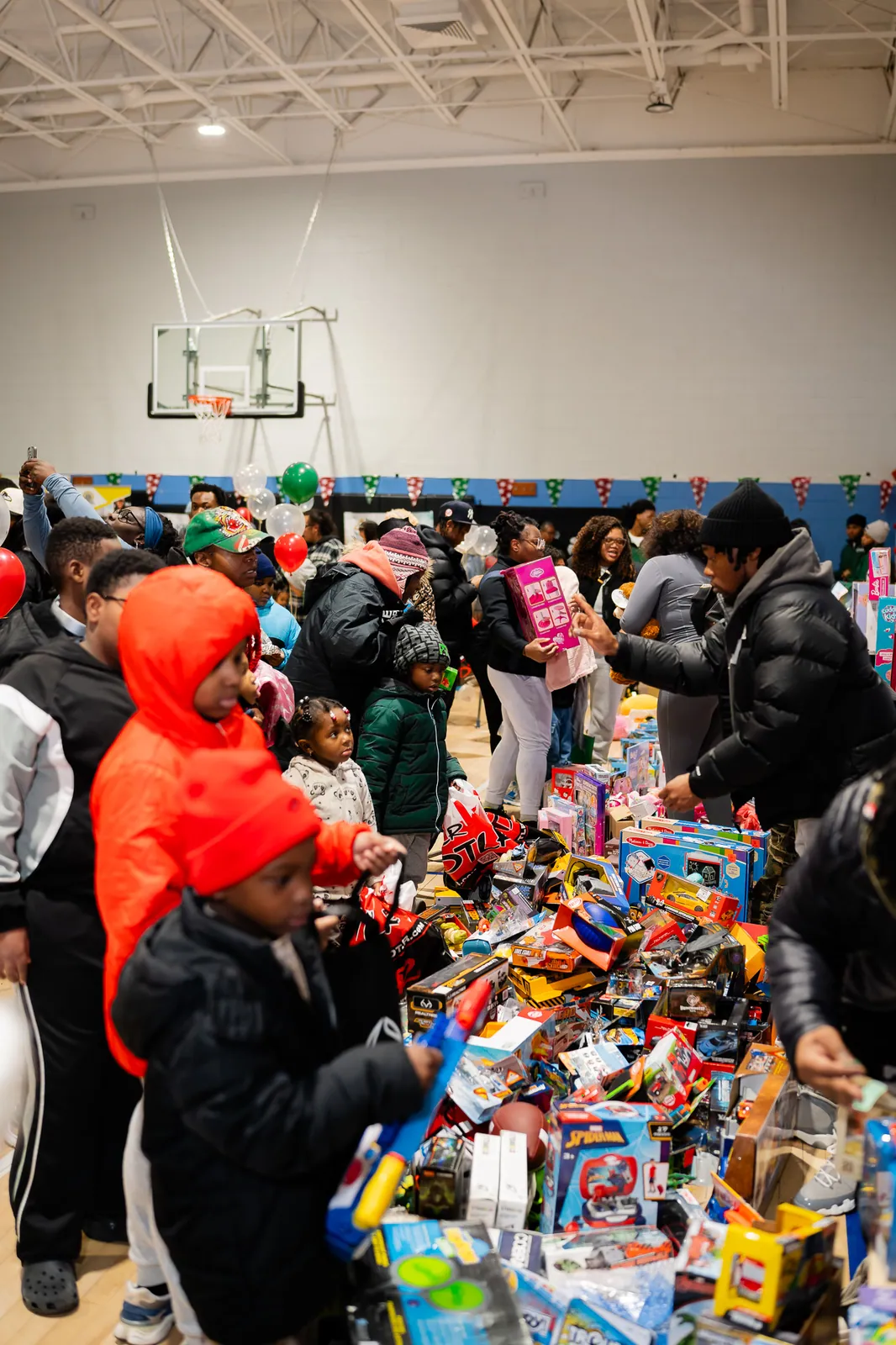 Families choosing toys from a table piled high at the KHA holiday drive