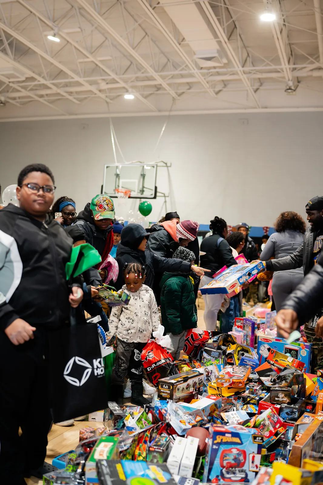 Children gathered around a table of toys at the holiday giveaway
