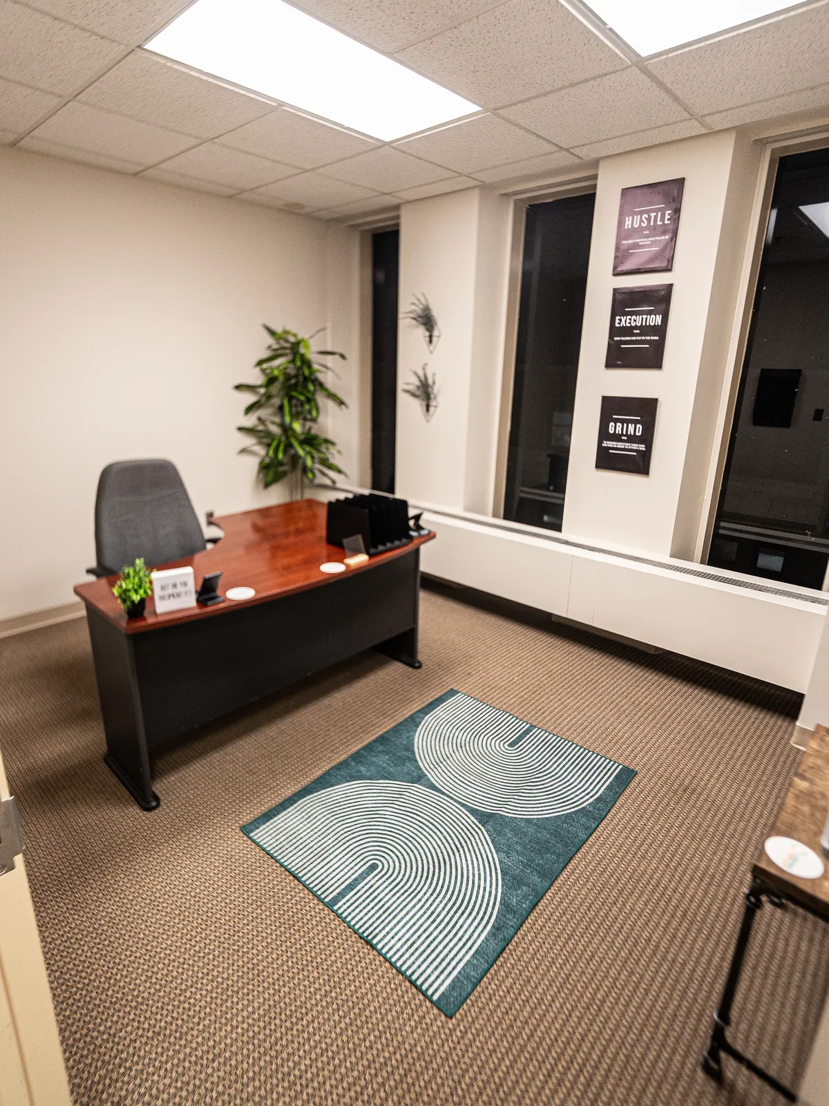 A KHA therapy office with a teal patterned rug and a wooden desk