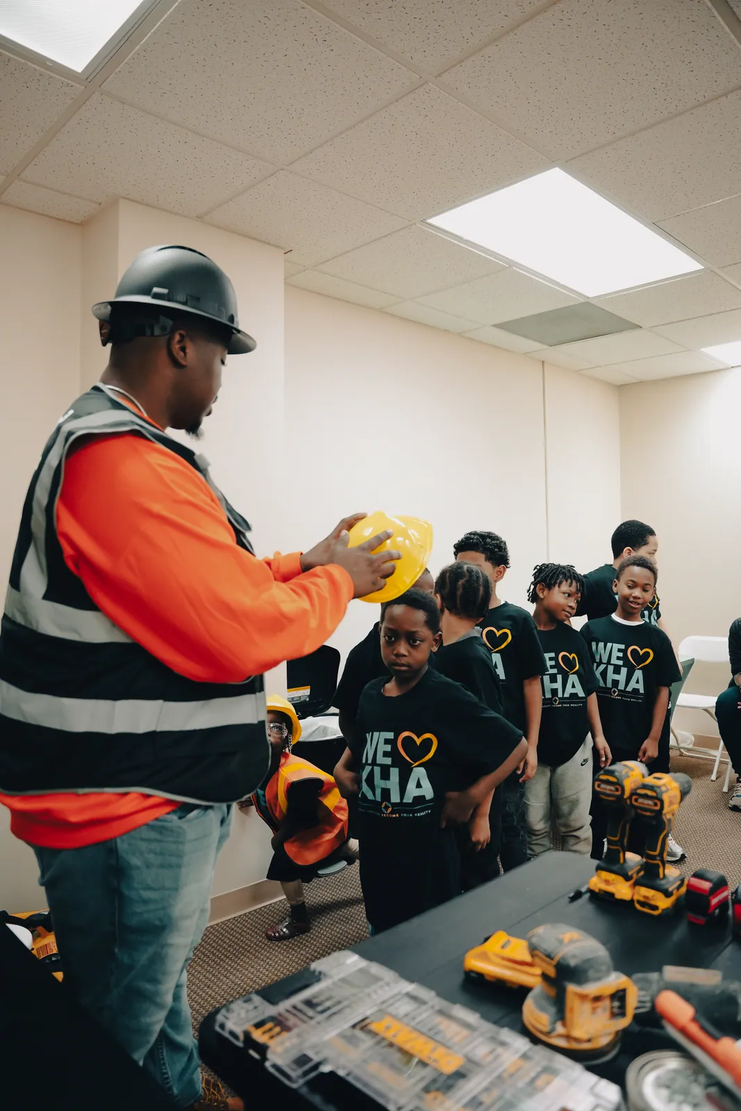 A construction mentor showing KHA youth how to use tools during a career workshop