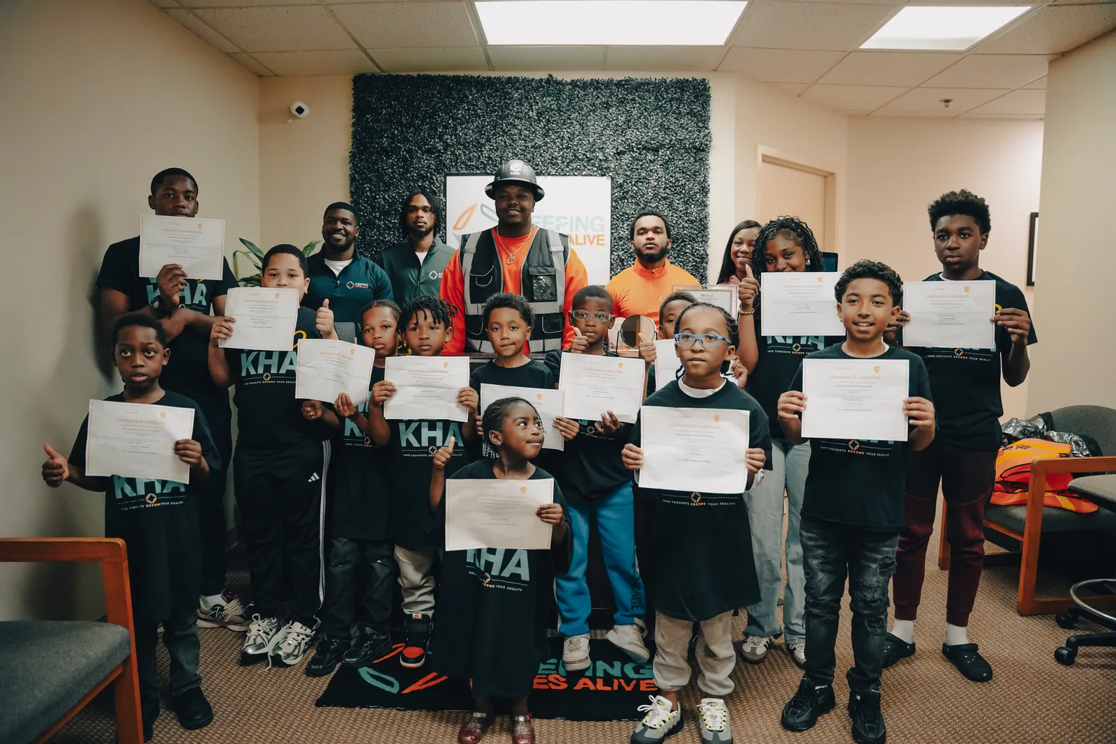 KHA youth holding certificates with their mentors after a workshop