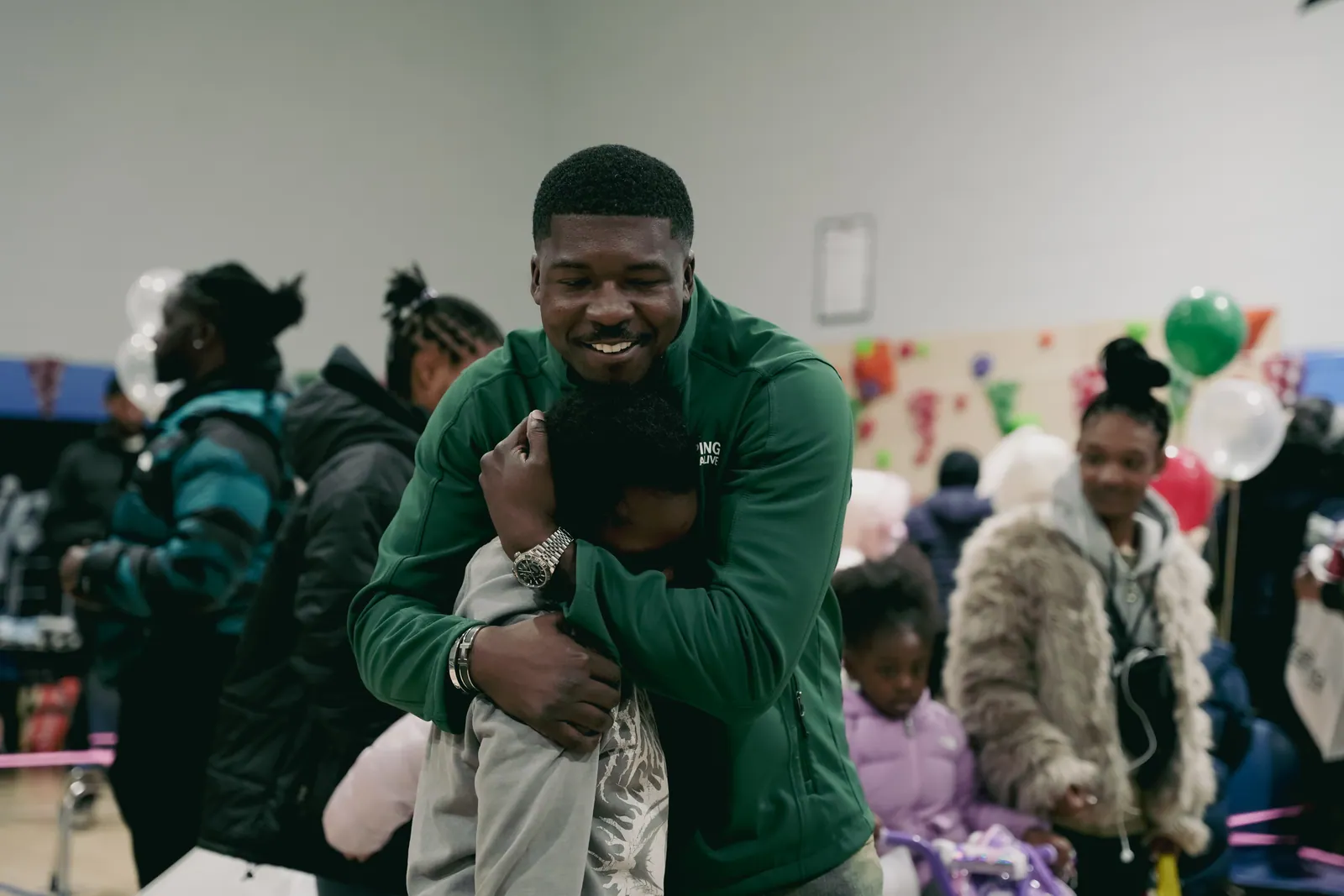 A KHA staff member sharing a hug with a child at the holiday drive
