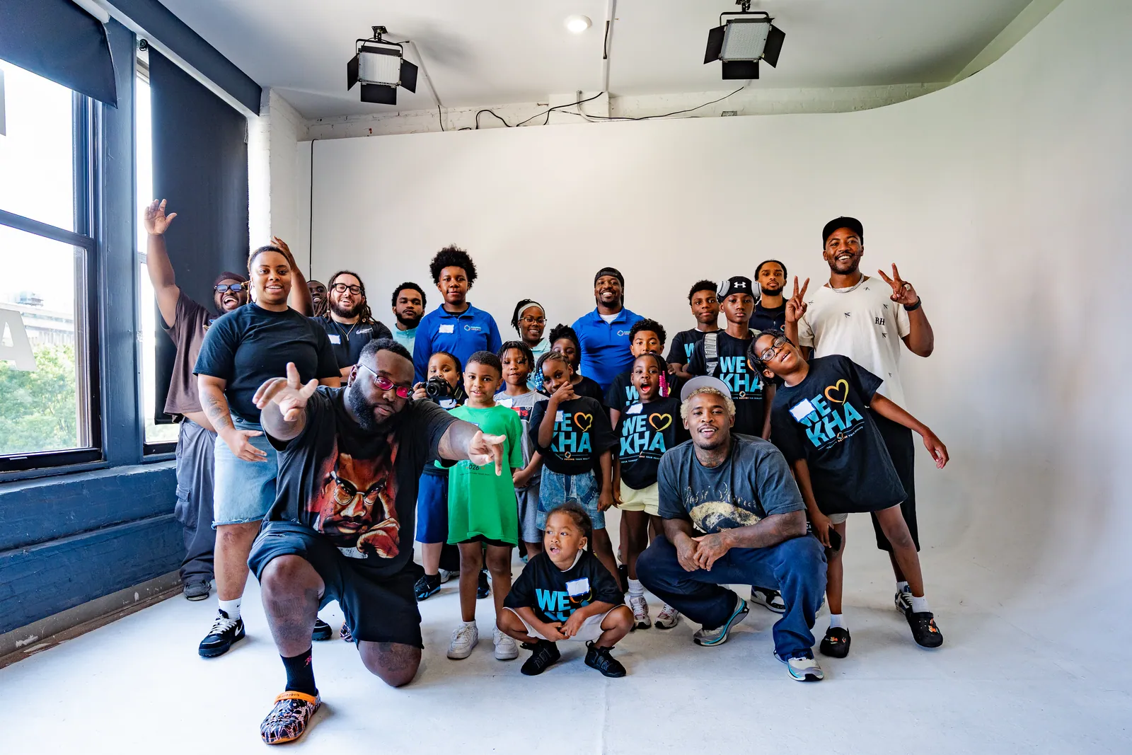 KHA youth and mentors smiling together in a photo studio