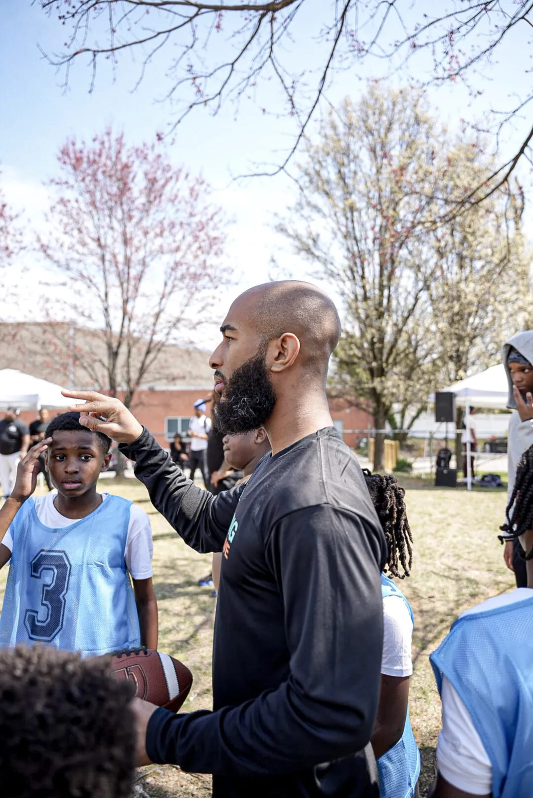 A KHA mentor coaching kids outside in the spring