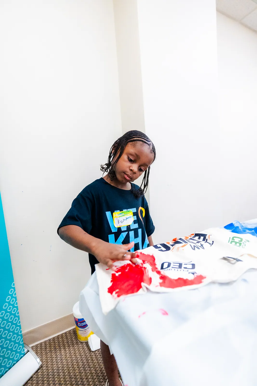 A girl painting a t shirt at the Peace in Printing workshop