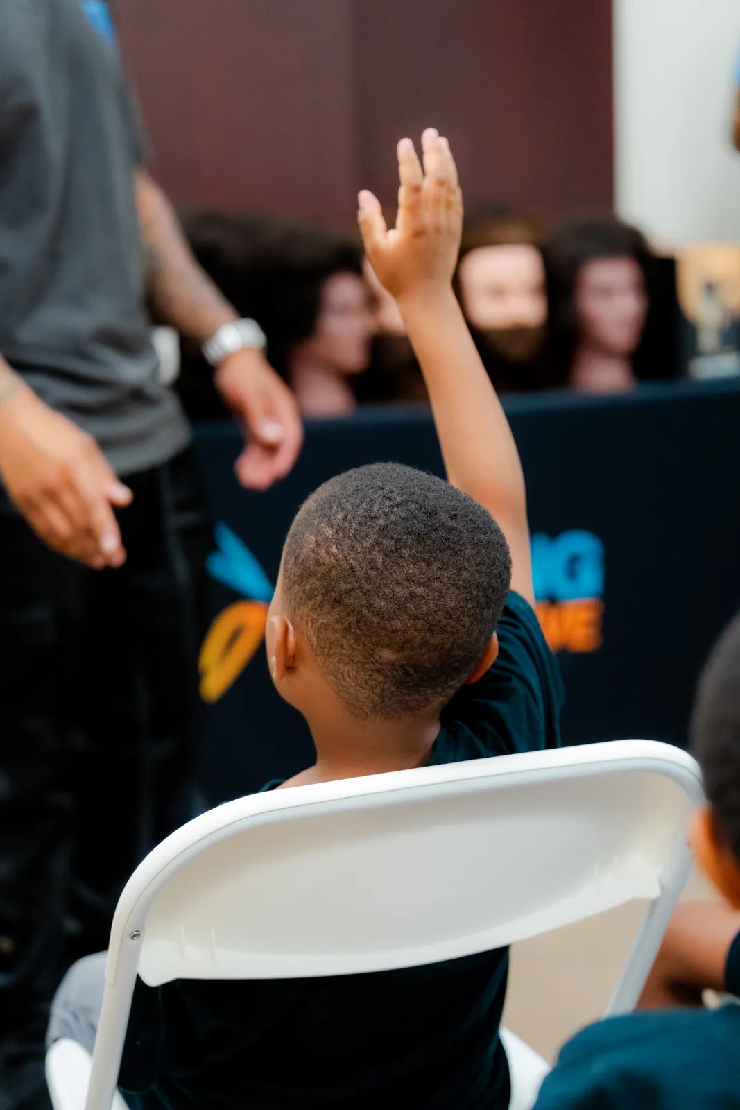 A KHA youth raising his hand during the Cuts and Confidence session