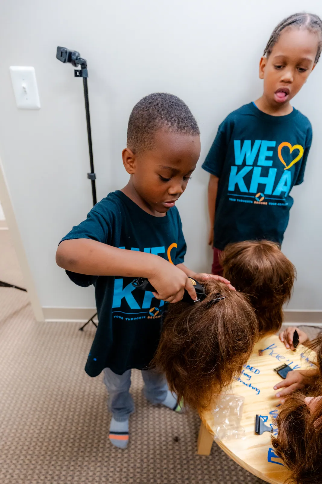 Young participants practicing barbering at Cuts and Confidence