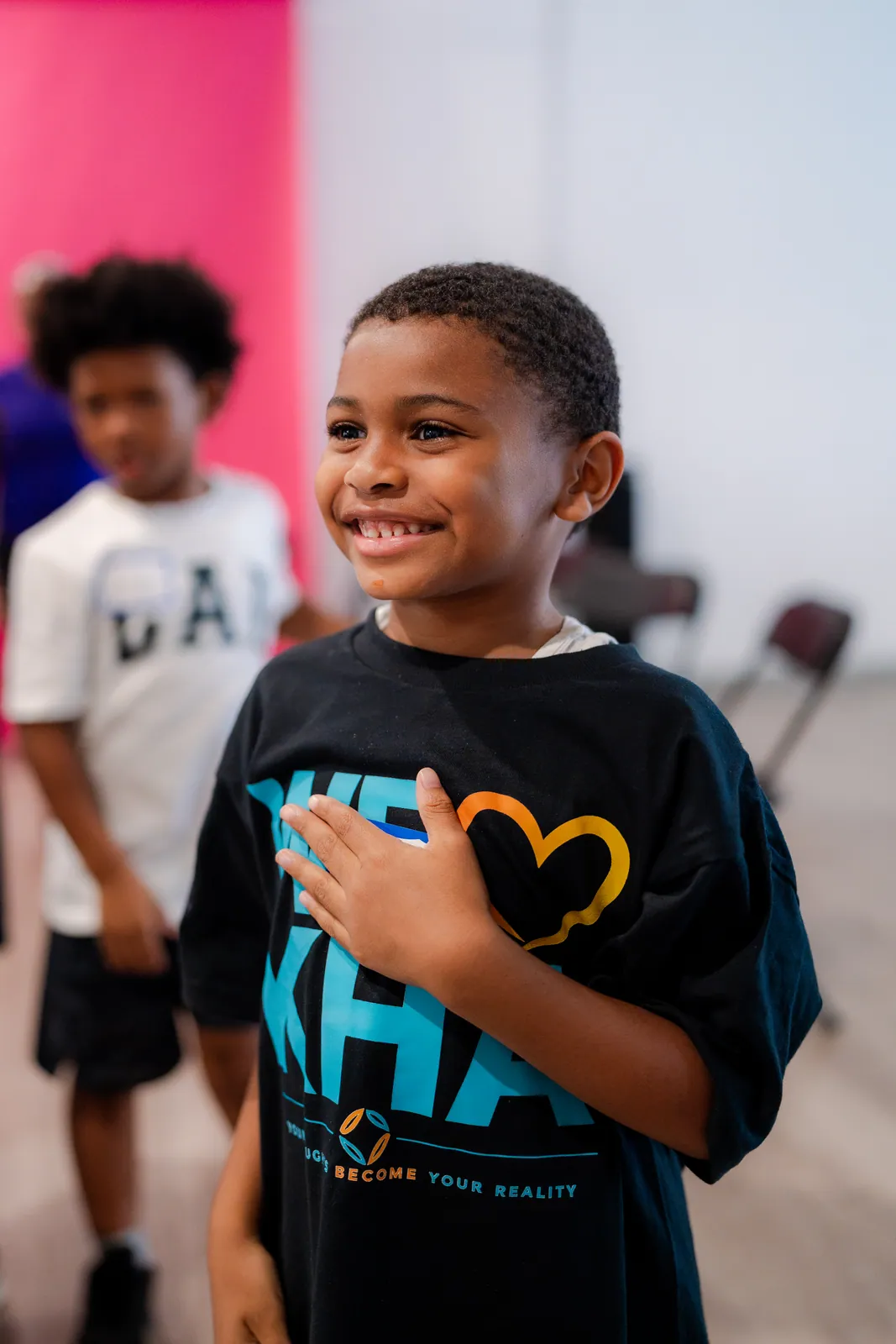A boy pointing up excitedly during a DGTL University session, in black and white