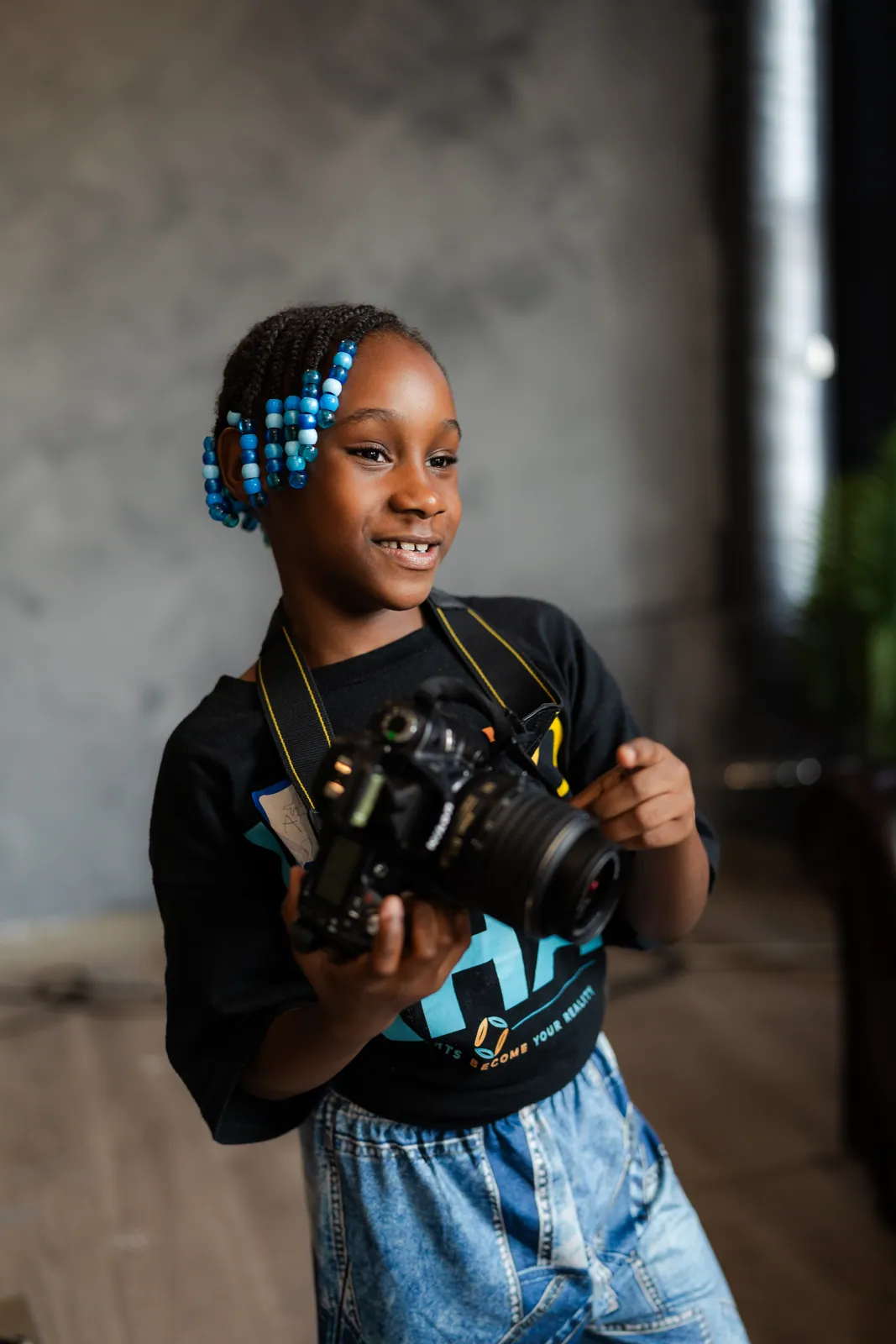 A girl holding a camera and smiling at DGTL University