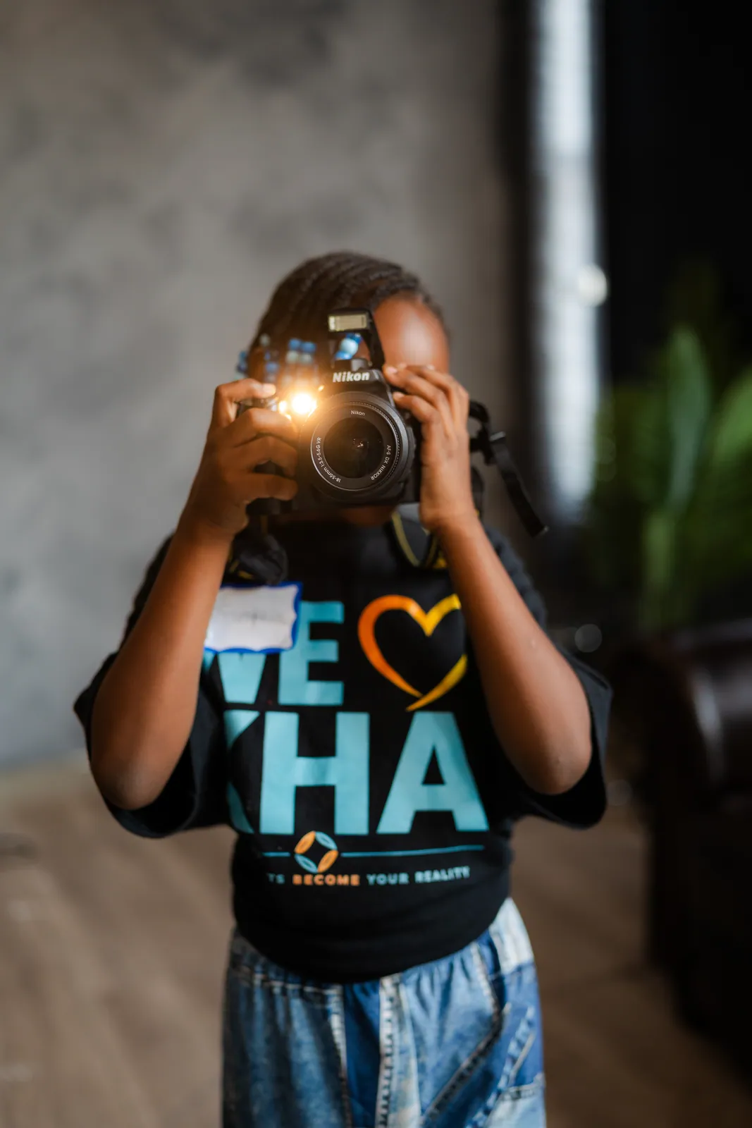 A KHA youth taking a photo with a camera at DGTL University