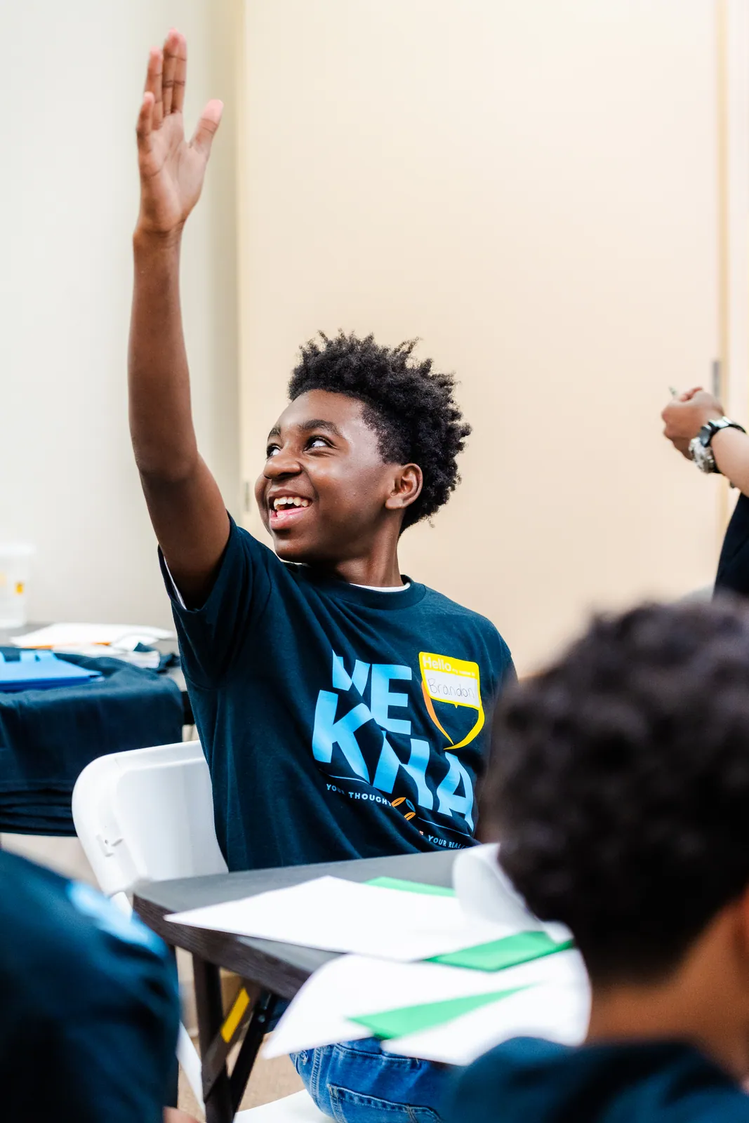 A smiling young participant raising his hand at the KHA finance workshop