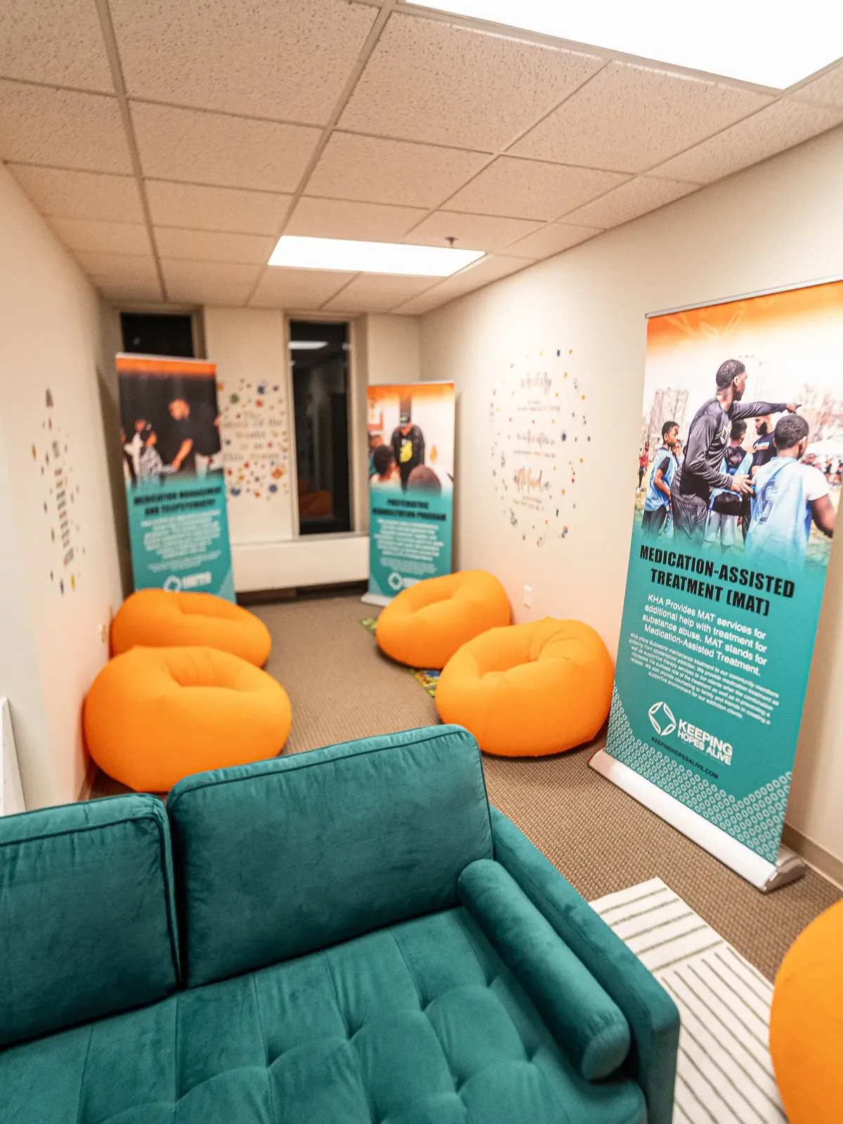The medication assisted treatment lounge at Keeping Hopes Alive with teal seating and program banners