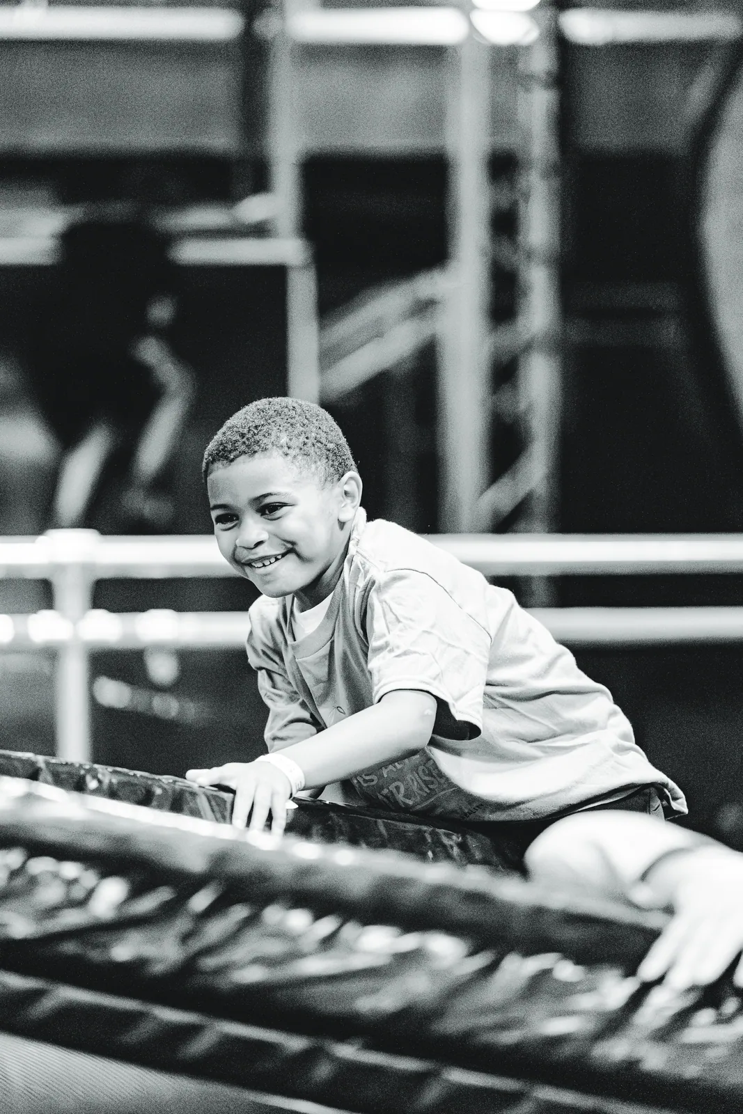 A boy climbing at Sky Zone, in black and white