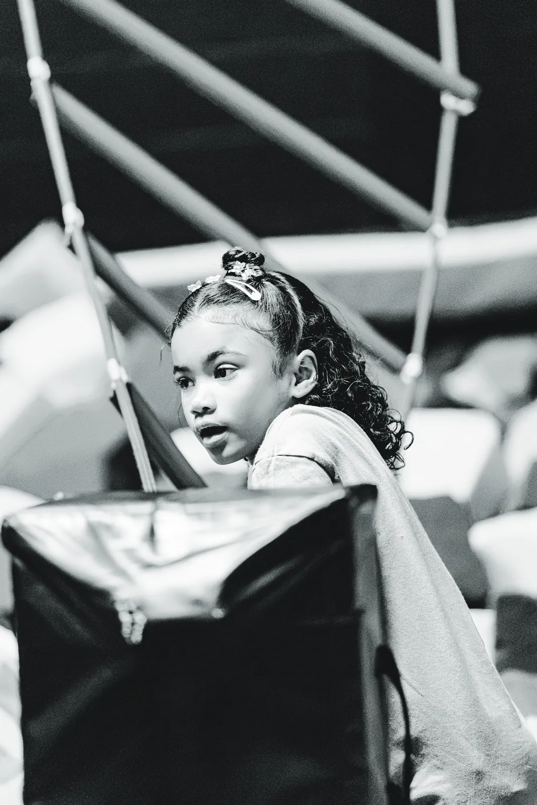 A girl playing in the foam pit at Sky Zone, in black and white