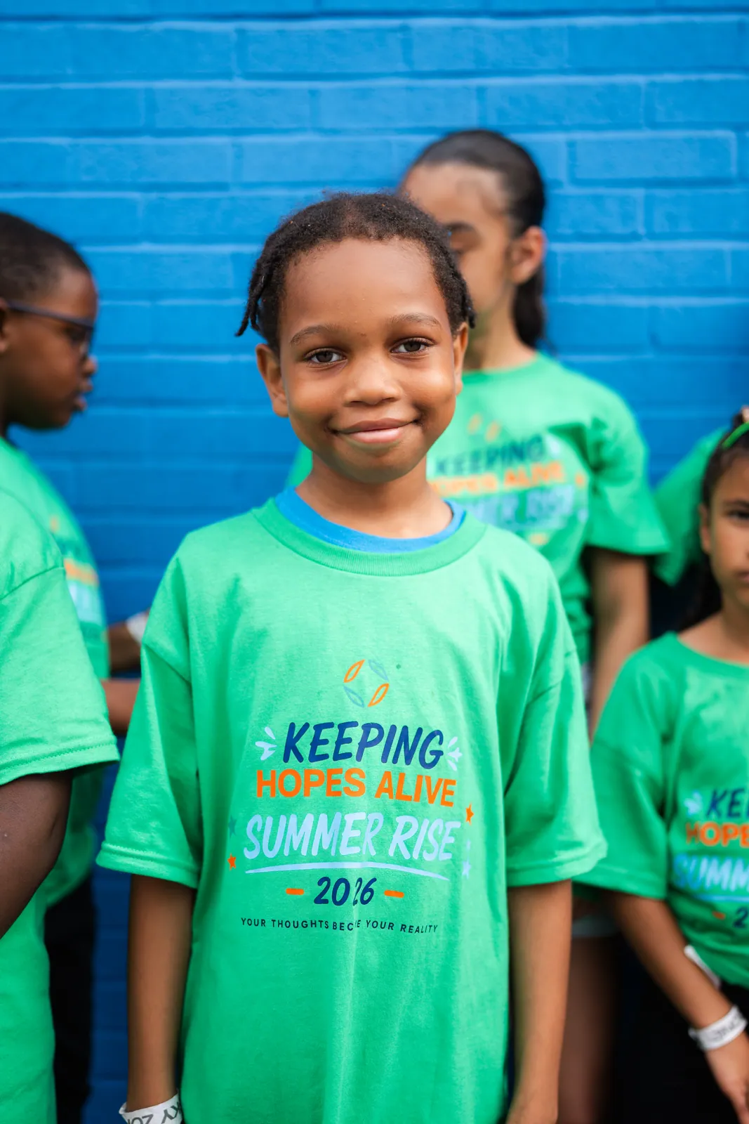A young girl in a Summer RISE shirt smiling at Sky Zone
