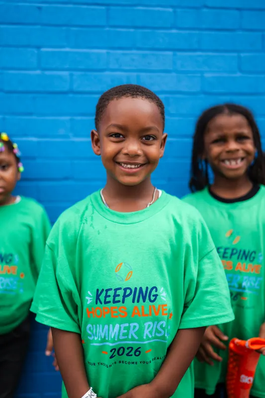 Two smiling kids in Summer RISE shirts