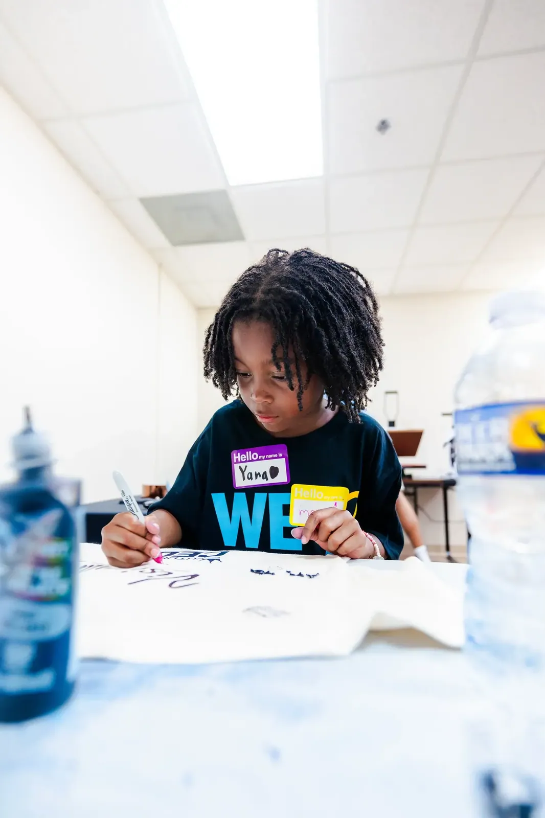 A young participant drawing a t shirt design