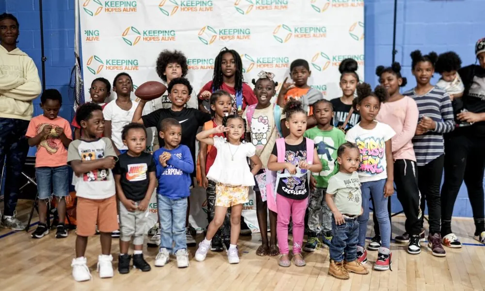Children and families in front of a Keeping Hopes Alive backdrop at the back-to-school drive