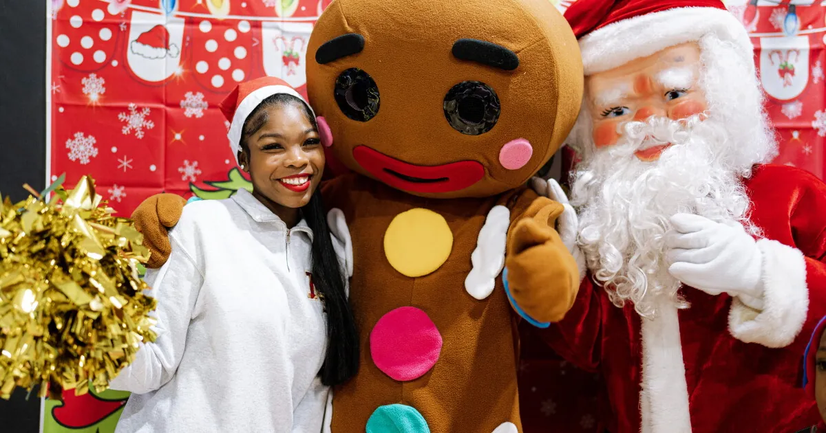 A cheerleader with a gingerbread mascot and Santa at the Sandtown Winchester holiday event